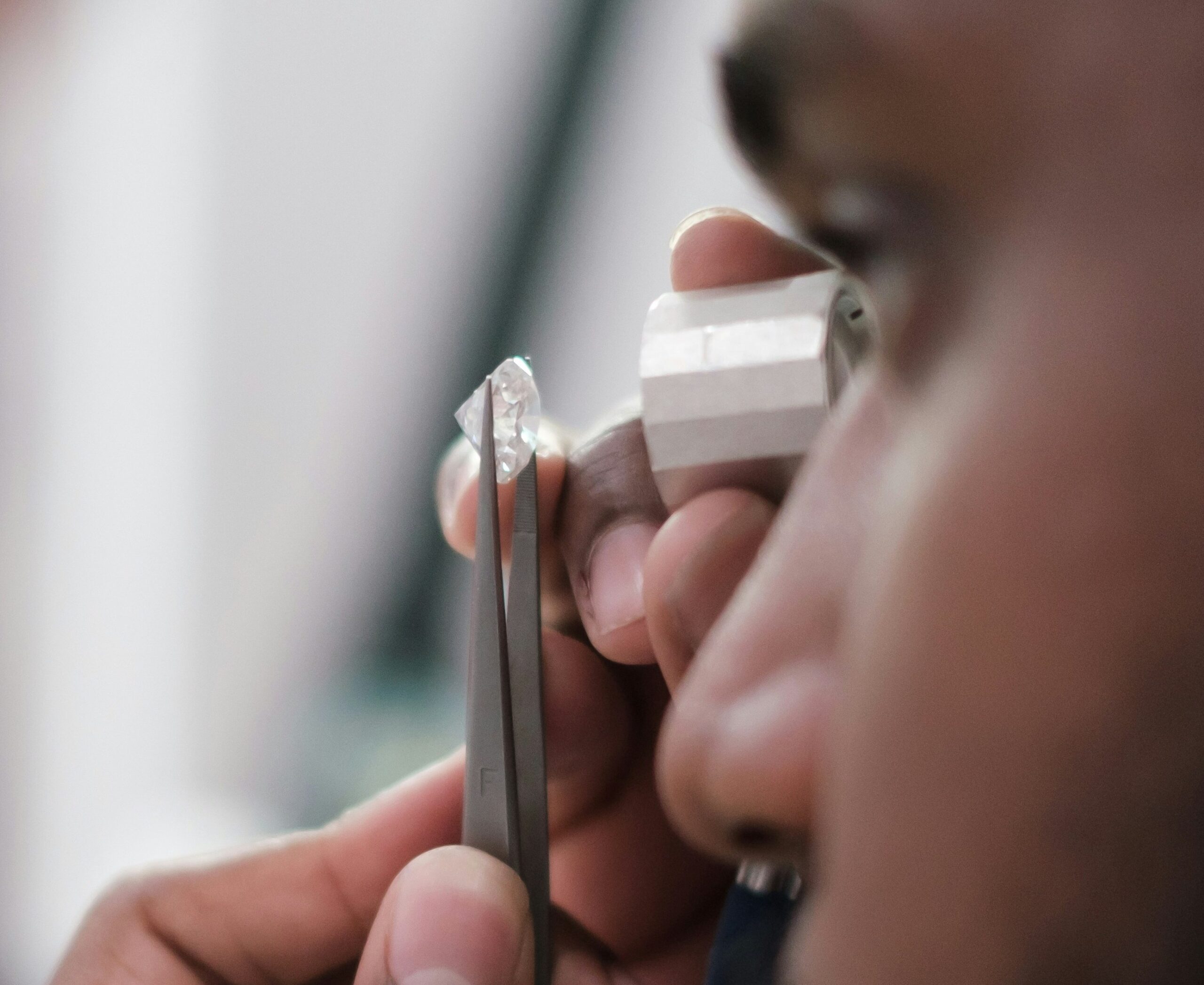 Close up of man grading diamond as part of jewellery valuation process