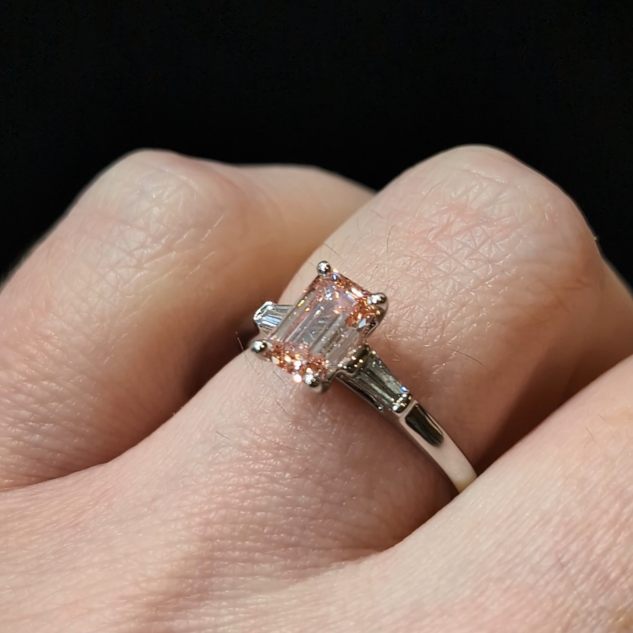 Pink diamond ring on finger