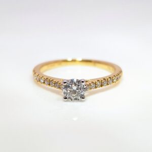 18ct yellow gold single stone diamond ring with a single round brilliant cut 0.40ct SI2 diamond in a white gold four claw setting, with diamond set shoulders on a plain polished band.